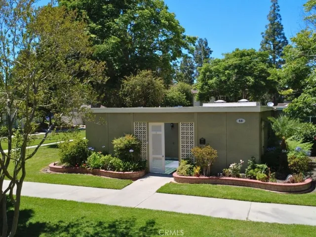 Another view of the front approach highlights the home's desirable end-unit location nestled among lush landscaping and mature trees.