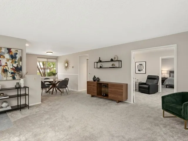 The comfortable living room flows seamlessly into the adjacent dining area, creating an inviting space for everyday living and entertaining. Virtually staged picture.