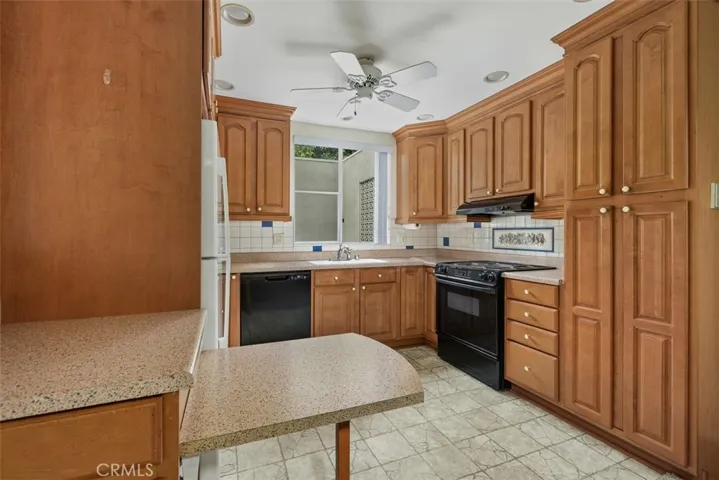 Warm wood cabinetry, quality finishes, and a functional floor plan make the kitchen both attractive and practical for daily living.