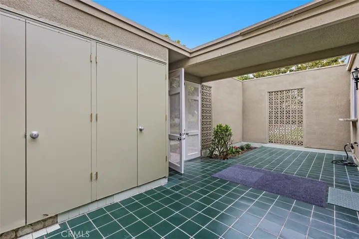 The enclosed courtyard provides a peaceful, low-maintenance outdoor space with direct access to the home, blending comfort and privacy. While the inside of the home has a combo washer and dryer, some have moved their units to this convenient storage area.