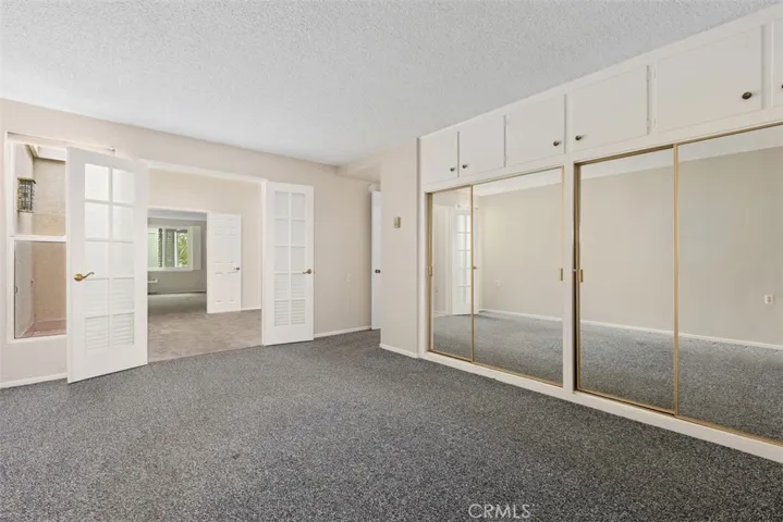 Another view of the versatile primary room highlights its spacious layout and abundant storage, allowing the room to easily adapt to a variety of lifestyles.
