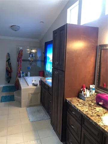 Primary bathroom with separate vanities and storage