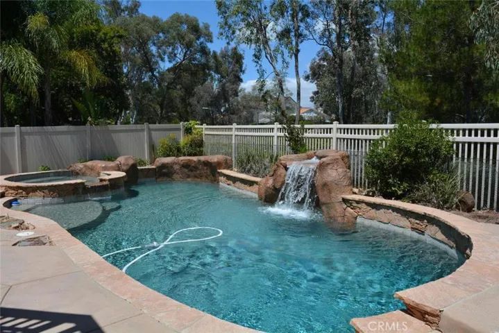 Refreshing pool and spa with elevated fire pit and seating area.