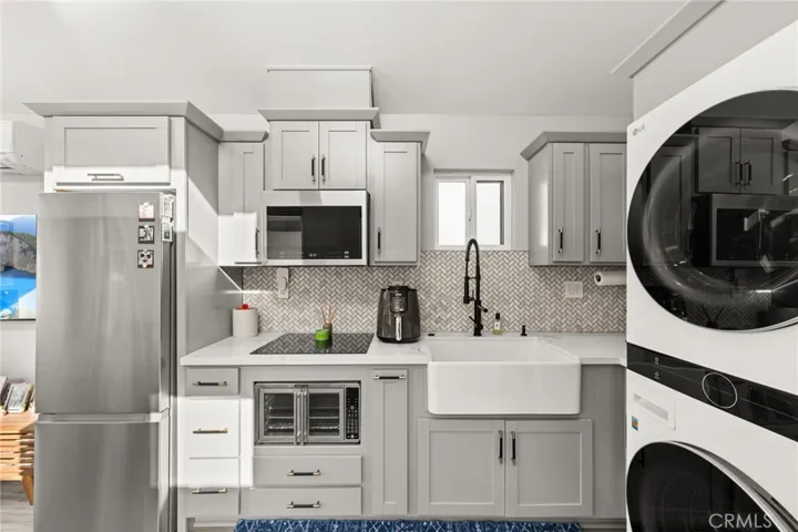 Kitchen with Built-In Oven, Farmhouse Sink, and Washer/Dryer