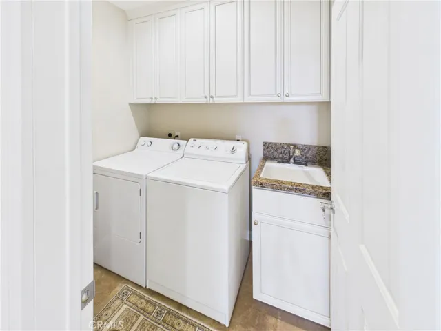 Full laundry ROOM with sink and cabinets. Washer and dryer included