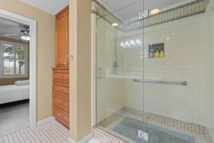 Shower and  custom built in storage in primary bathroom 1
