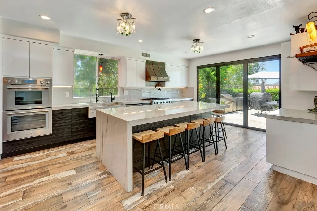 Spacious gourmet luxury kitchen featuring high-end appliances, elegant stone countertops, a large center island, and ample modern cabinetry perfect for everyday living, entertaining, and gatherings