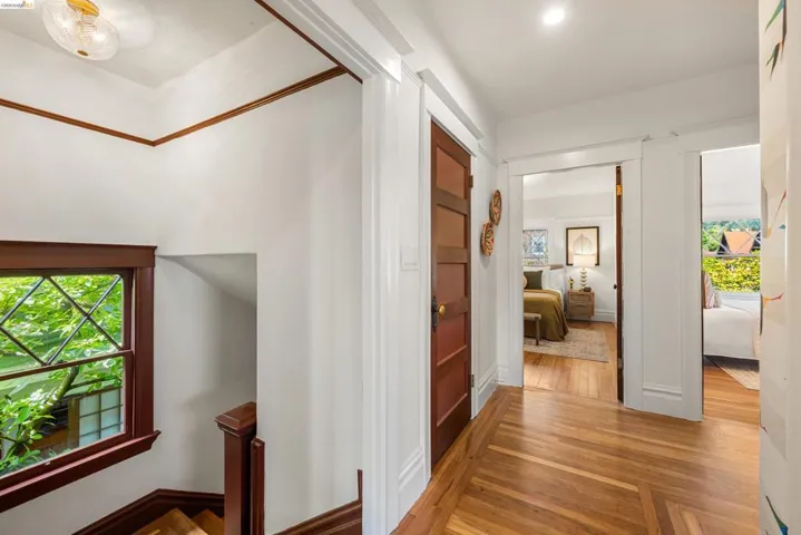 Upper landing featuring rich wood-finish flooring with a herringbone pattern