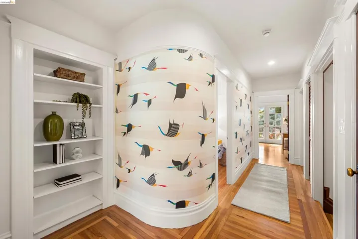 Hallway featuring decorative wall covering, hardwood flooring, built-in shelving, and recessed lighting