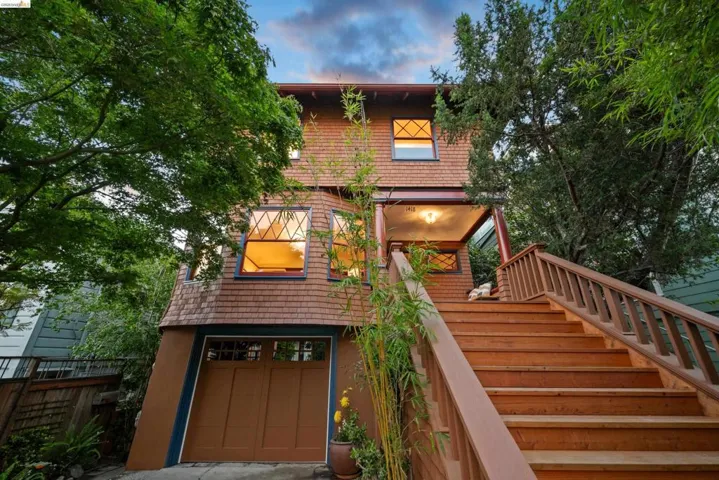 Multi-level facade featuring wood shake siding and a prominent bay window with diamond-patterned grilles