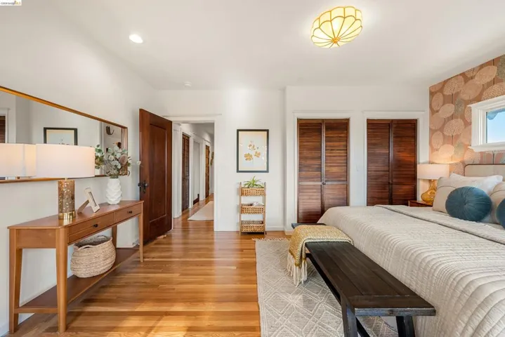 Hardwood flooring throughout this room, featuring a decorative ceiling light fixture and a window