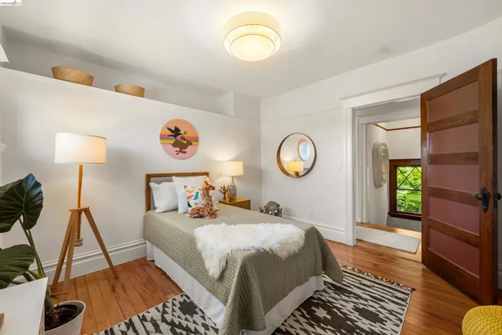 Hardwood flooring and white baseboards define this room, featuring a built-in shelf ledge