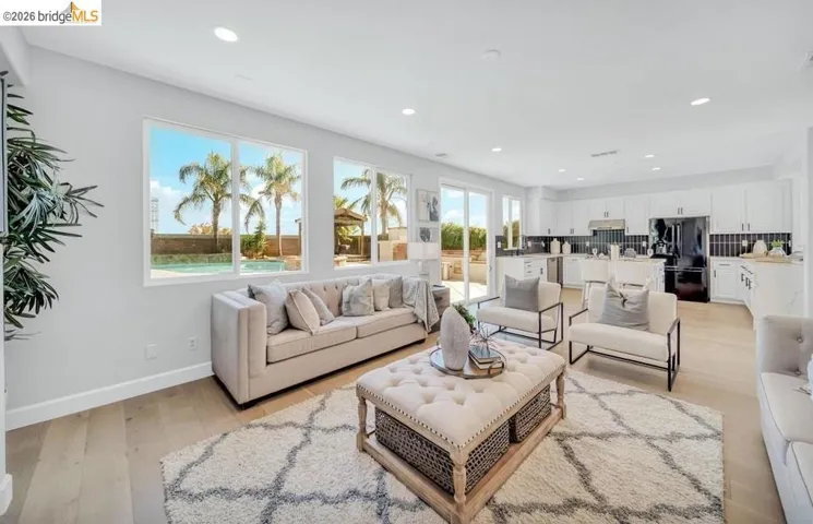 Open-concept living space featuring wood-finish flooring, recessed lighting, and expansive windows