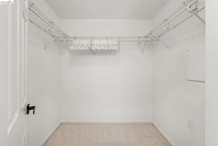 Walk-in closet featuring wire shelving and hanging rods