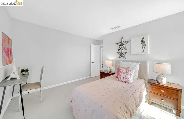 Light gray walls with white baseboards, a light-colored carpet, and a white ceiling with a visible vent