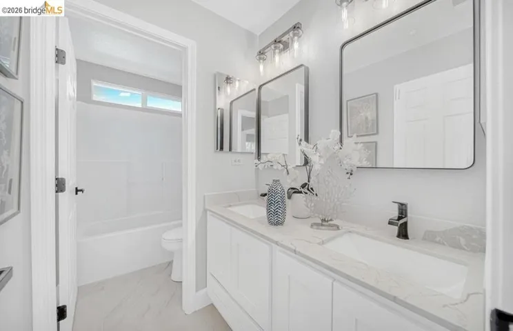 Dual vanity with white cabinetry, quartz countertop, and rectangular undermount sinks