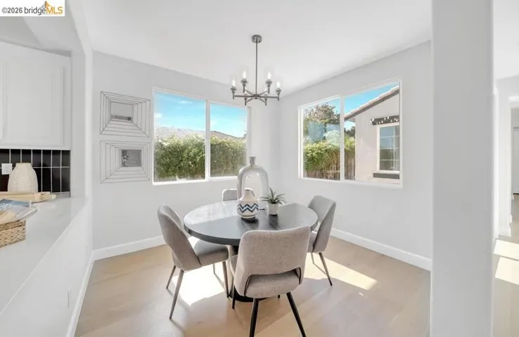 Open dining space featuring wood-finish flooring and a contemporary chandelier