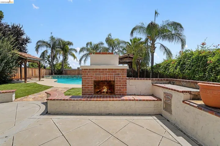Outdoor fireplace with brick surround, integrated seating, and built-in compartments