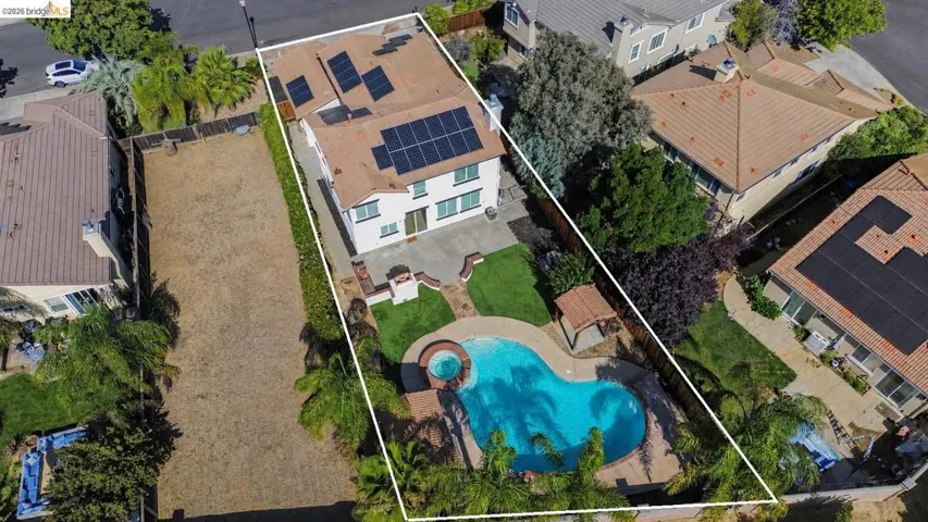 Expansive backyard oasis featuring a freeform swimming pool, integrated spa, and surrounding patio
