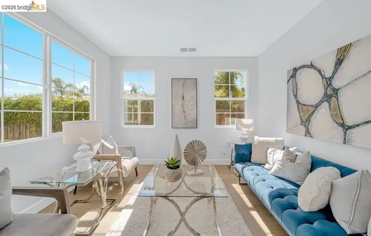 Bright living area featuring light-toned walls and wood-finish flooring