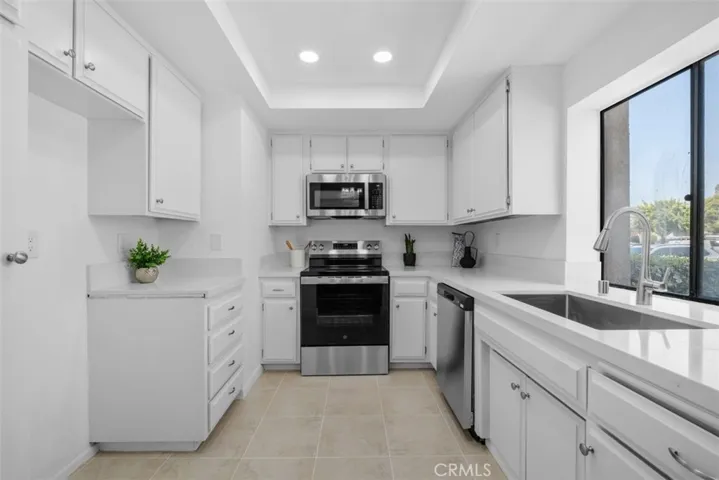 Kitchen with Quartz Countertops, White Cabinets and Recessed Lighting