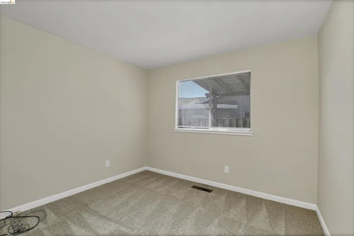 Neutral wall finishes, window with blinds, baseboard trim, and carpeted flooring