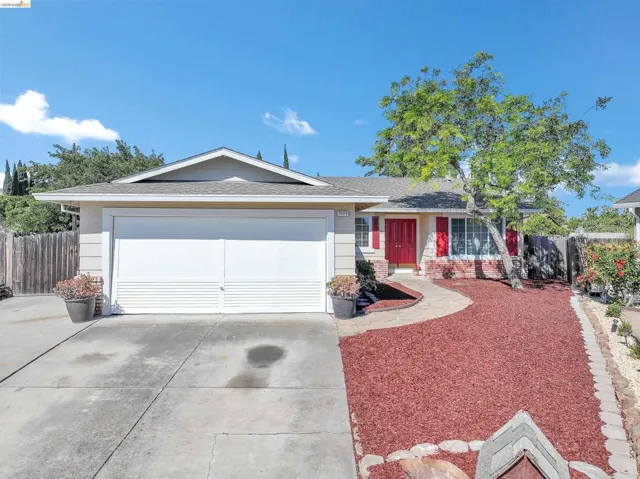 Single-story residence featuring a two-car garage, red front door, and red window shutters