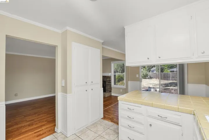 Kitchen area featuring white cabinetry, a tiled countertop, and a tiled floor