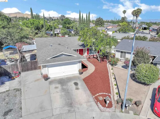 Front exterior featuring a two-car garage, concrete driveway, and red mulch landscaping