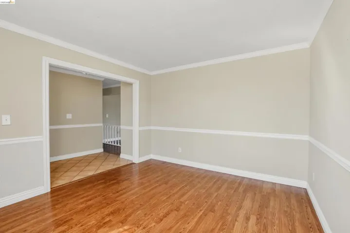 Wood-finish flooring throughout, complemented by a light neutral wall color with chair rail molding