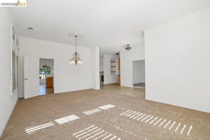 Expansive carpeted living area with white walls
