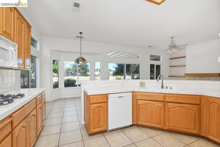 Kitchen featuring wood cabinetry, white tile countertops, and a built-in gas cooktop