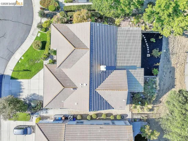 Pitched roofline residence with neutral-toned shingles, featuring solar panels on one roof section