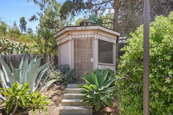 Gazebo converted to a chicken palace with chickens! Established foliage and trees in the backyard.