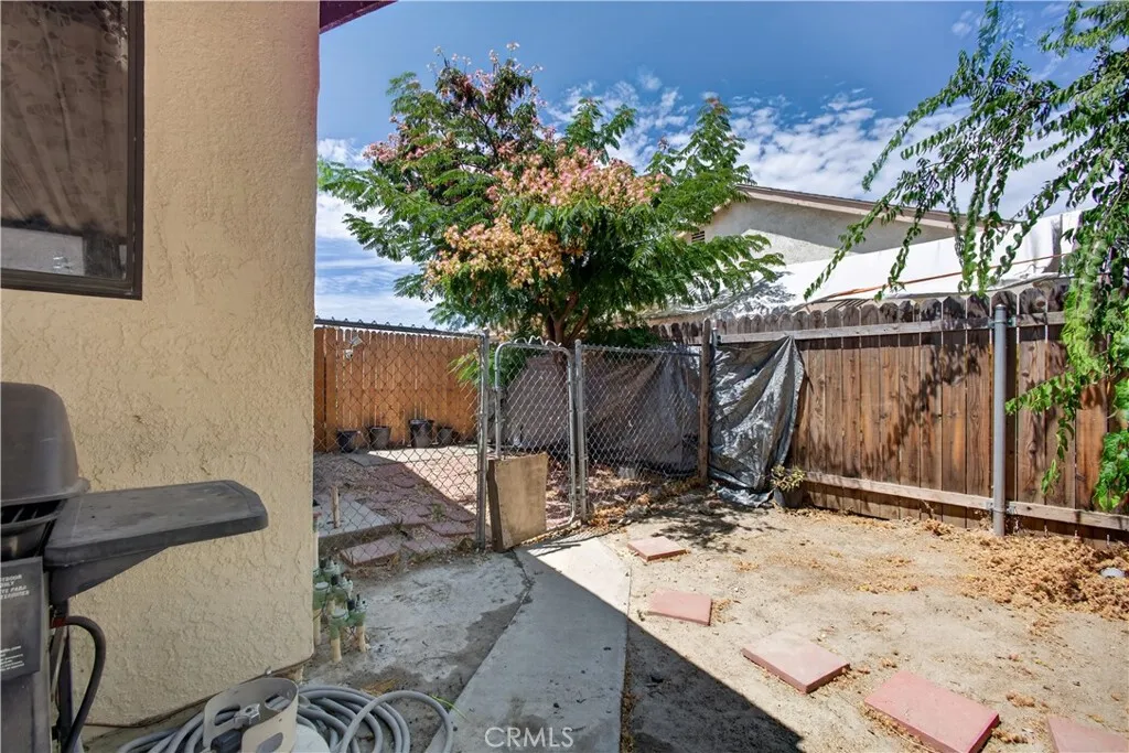 Right-side yard with secured fenced area ideal for pets.