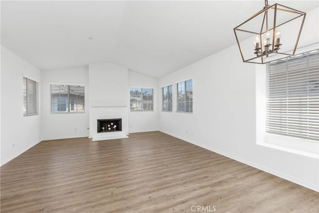 Open and spacious living and dining room combination enhanced by soaring vaulted ceilings and a cozy fireplace that creates a warm and inviting atmosphere