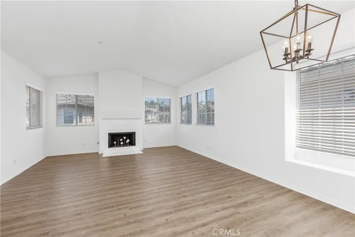 Open and spacious living and dining room combination enhanced by soaring vaulted ceilings and a cozy fireplace that creates a warm and inviting atmosphere