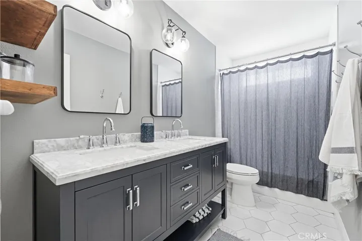 Full secondary bath with tub and shower in tub, new white marble/quartz double sink. Completely remodeled including tub, shower floors.