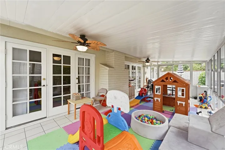 Two sets of French doors and ceiling fans access the sun room.