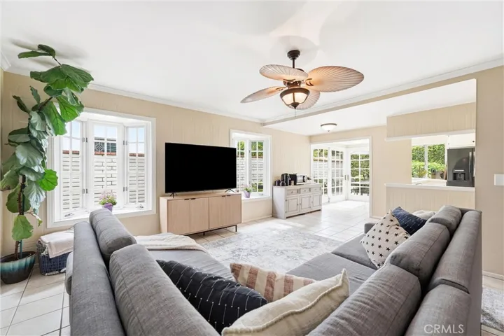 Family Room with kitchen to the right, ceiling fan and French windows with window seats
