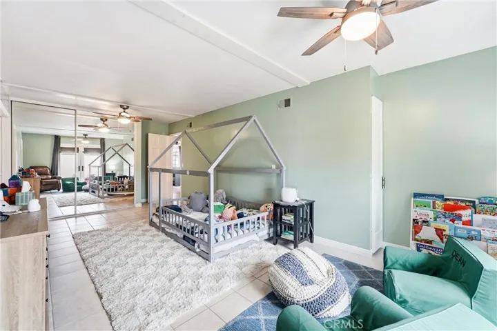 Extra large secondary bedroom with ceiling fan and French doors to the front courtyard