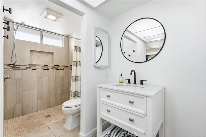 Primary bath suite with newer vanity and toilet.