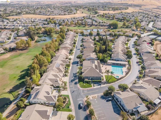 Aerial overview of a residential community featuring mature landscaping and a curving street layout