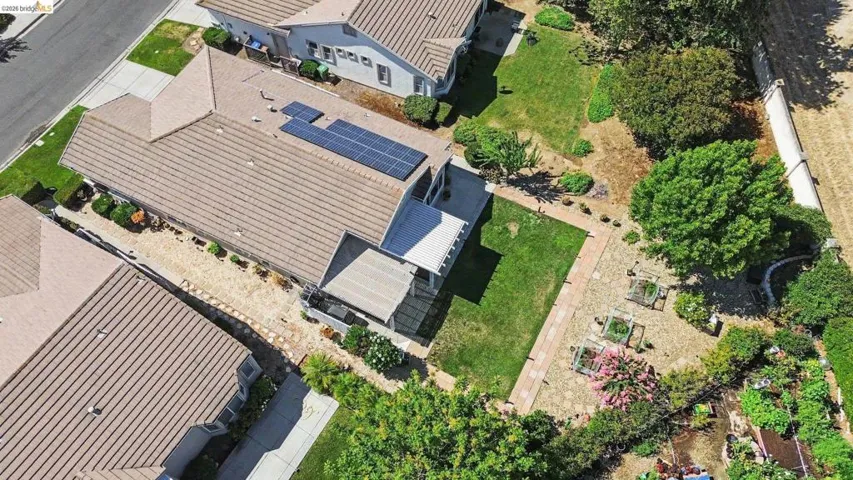 Aerial view of a residential property featuring a tiled roof and solar panels