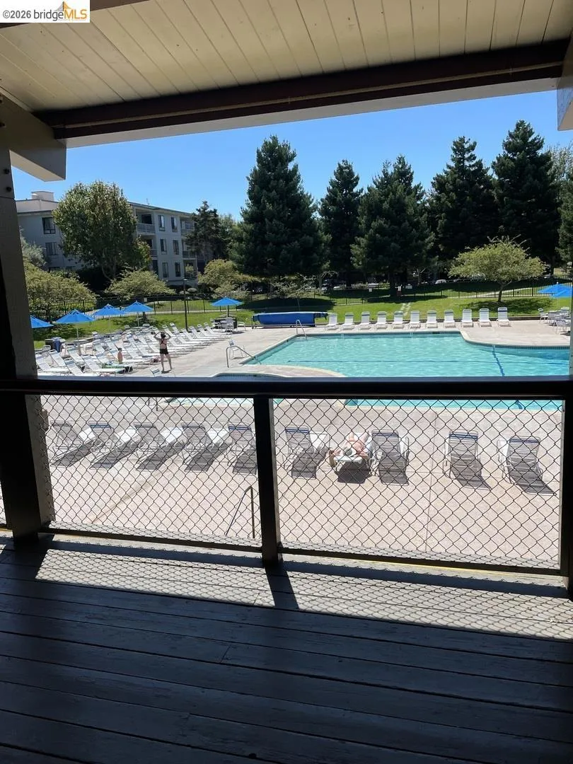 Outdoor balcony with wood-finish flooring and chain link railing