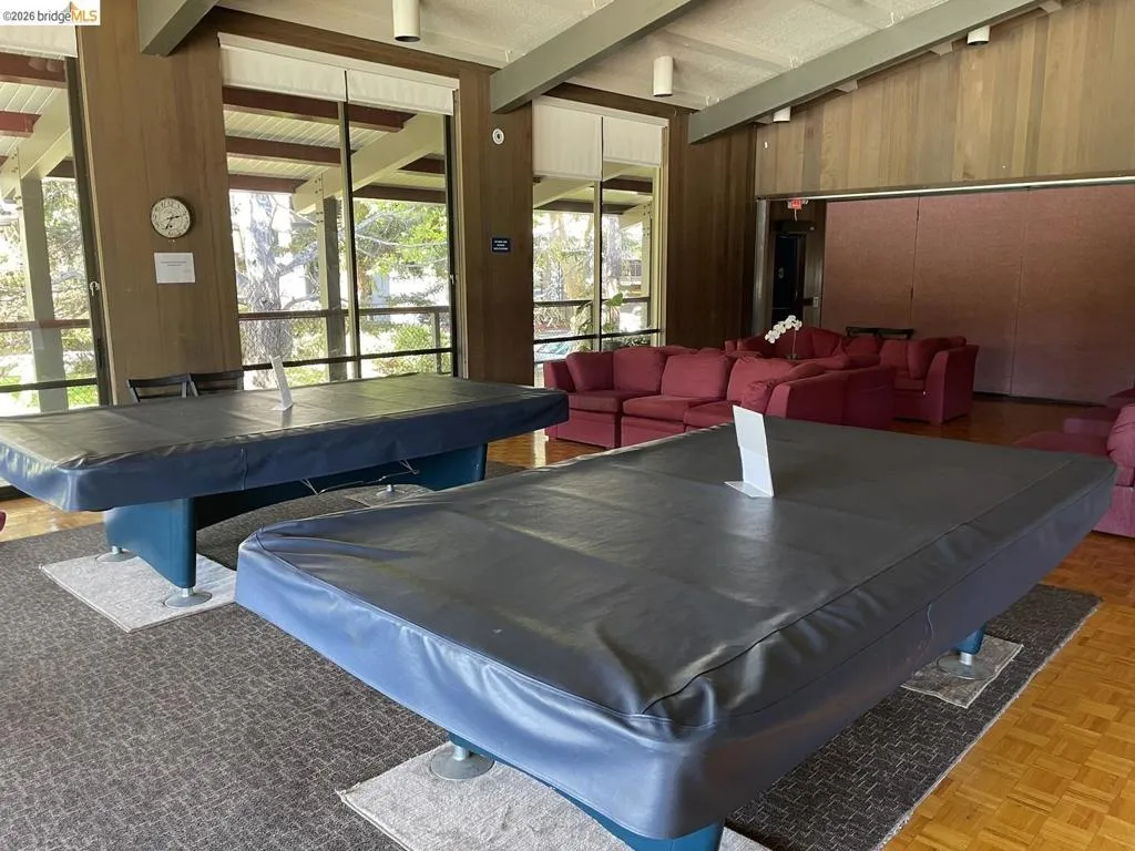 Recreational room featuring two covered billiard tables on carpeted areas