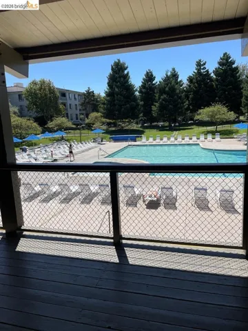 Outdoor balcony with wood-finish flooring and chain link railing