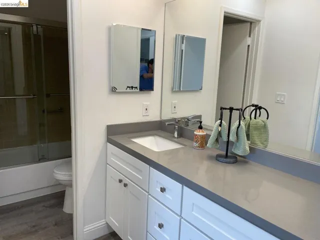 Bathroom featuring a modern vanity with white shaker-style cabinetry, a single undermount sink, and a gray countertop