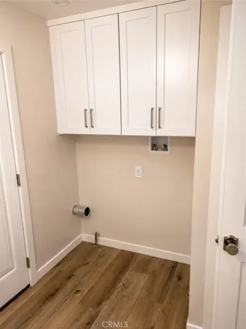 Laundry room with overhead cabinets