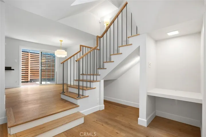 Wood floors with custom railing. Built in desk space, and under staircase space for dog bed or wine storage.